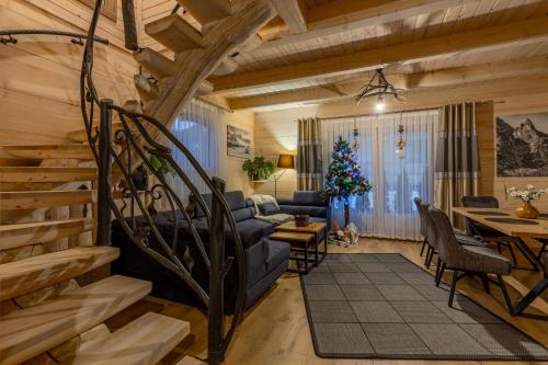 a living room with a couch and a table at Leśny Dwór Premium Chalets Zakopane in Murzasichle
