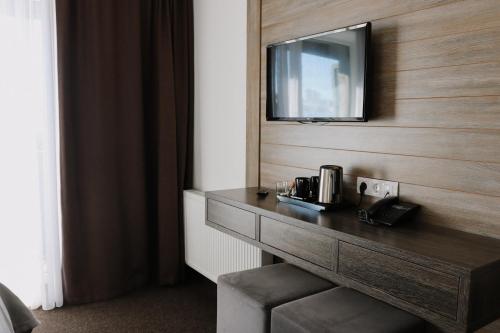 a hotel room with a desk with a television on the wall at VILSON hotel in Bukovel