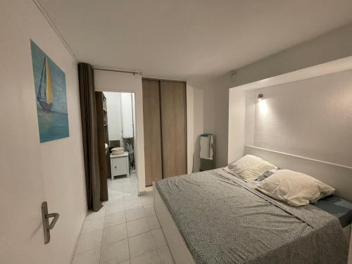 ein Schlafzimmer mit einem Bett und einer Tür zu einem Bad in der Unterkunft Appartement bord de mer avec piscine in Vallauris