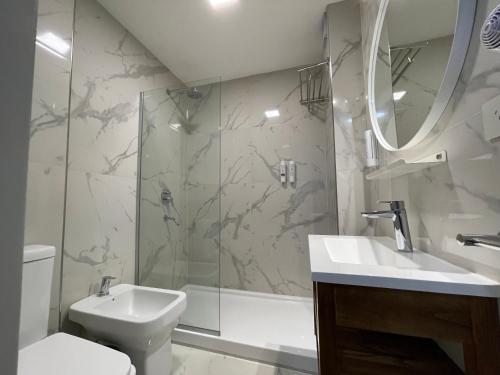 a bathroom with a shower and a sink and a toilet at Hotel 8 de Octubre in Buenos Aires