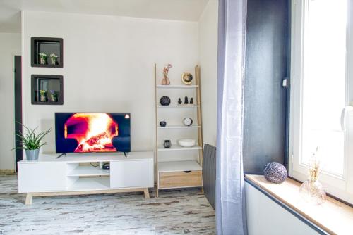 un salon avec une télévision sur un meuble blanc dans l'établissement Le 15 - Appartement pour 4 personnes - Disneyland Paris, à Esbly