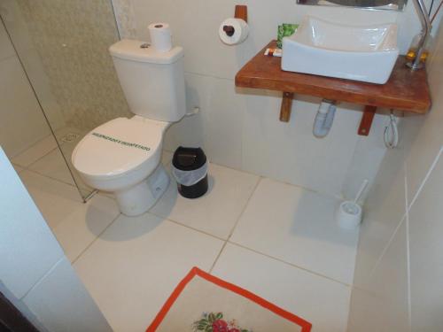 a bathroom with a toilet and a sink at Chalé Palhano Beach in São Miguel dos Milagres