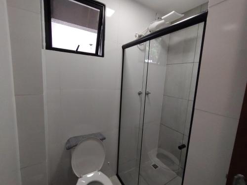 a bathroom with a toilet and a glass shower at Xavi Studio in Bauru