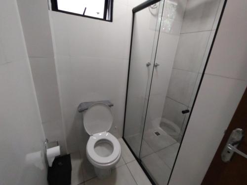 a bathroom with a toilet and a glass shower at Xavi Studio in Bauru
