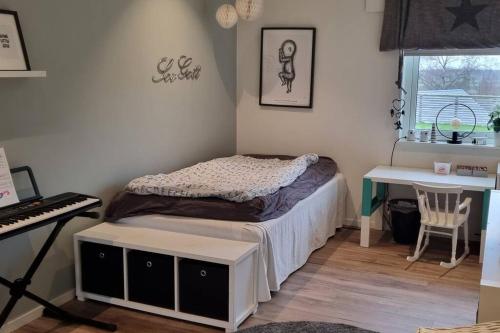 um pequeno quarto com uma cama e um teclado em Uthyres endast till barnfamiljer em Gullbrandstorp