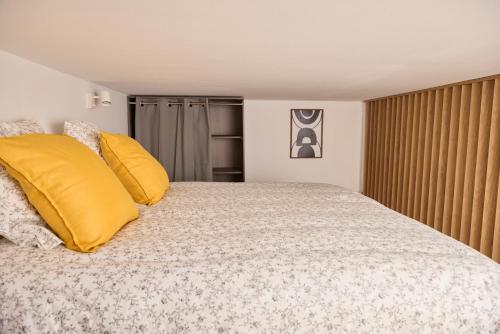 um quarto com uma cama grande e almofadas amarelas em Tinyhouse Experience in Beaujolais em Villefranche-sur-Saône