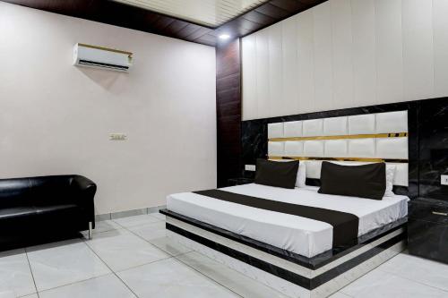 een slaapkamer met een groot bed en een zwarte stoel bij OYO Flagship Hotel A&S in Rohtak