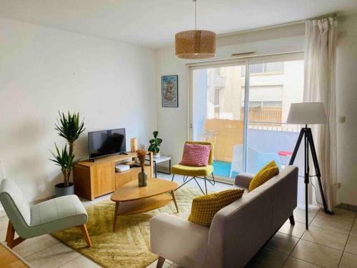 a living room with a couch and chairs and a television at Le Viarm'Élite in Nantes