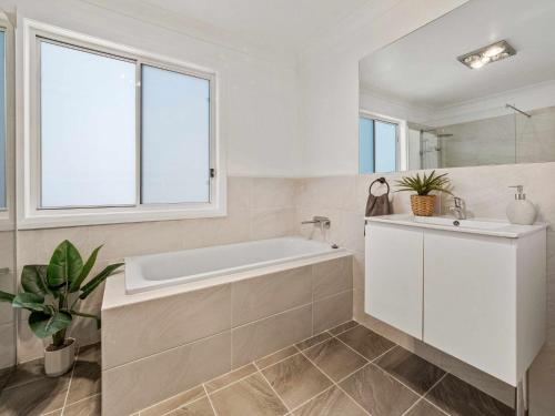 a white bathroom with a tub and a sink at Allendale in Berridale