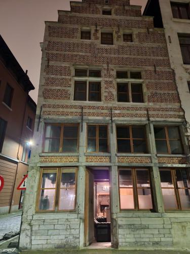 a tall brick building with a purple door at Viktoria HOSTEL in Antwerp