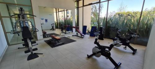 a gym with exercise bikes and ellipticals in a building at Apartamento cerca Mall Alto las Condes in Santiago