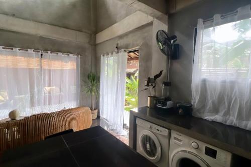 a kitchen with a washing machine and a window at 2 bedroom family house in Lodge in General Luna