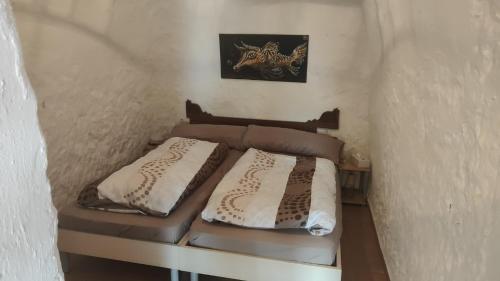 1 dormitorio con 2 camas en una habitación pequeña en Cuevas Althea en Baza