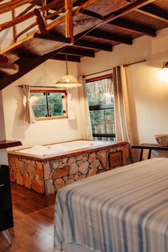 a bedroom with a bed and a stone bench at Vila Ypáwa 150 m centro 30 m praia lago verde in Alter do Chao