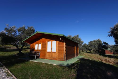 a small wooden cabin in a field with trees at El Bosque de Ribera in Escalona