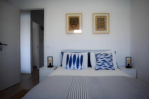 a bedroom with a bed with blue and white pillows at Apartamentos Playa de Mogro in Miengo
