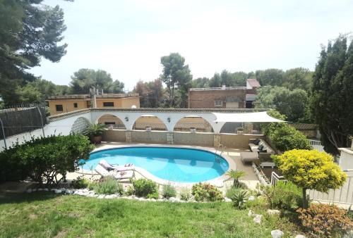 a large swimming pool in a yard with a landscaping at Chalet acogedor en La Mora in Tarragona