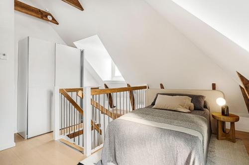 a white bedroom with a bed and a staircase at Central beautiful modern accommodation near Stockholm City in Stockholm