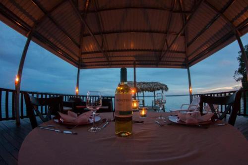a bottle of wine sitting on a table with wine glasses at Ribiera del Lago Peten Itza in Flores