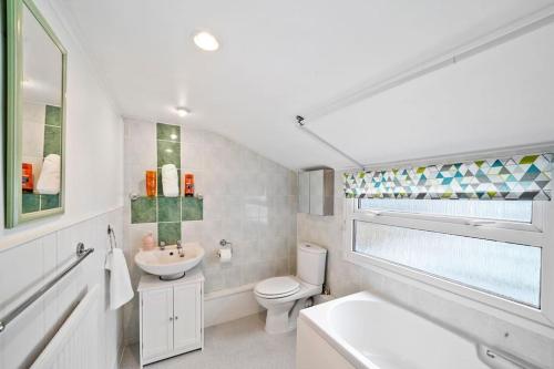 Baño blanco con aseo y lavamanos en Beautiful 2 bedroom house Free Parking, Aylesbury, Adrenham st, en Buckinghamshire