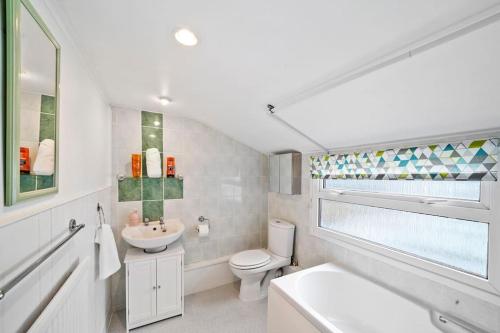 ein weißes Badezimmer mit Toilette und Waschbecken in der Unterkunft Beautiful 2 bedroom house Free Parking, Aylesbury, Adrenham st in Buckinghamshire