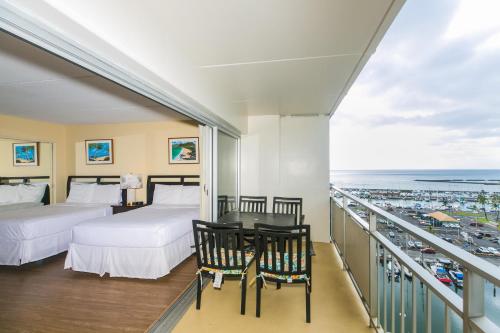 a bedroom with two beds and a table and chairs at Ilikai Tower 1137 Yacht Harbor View 1BR in Honolulu