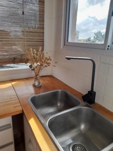 a kitchen sink with a vase of flowers next to a window at Casa vacacional LUNA DE MAR in Santa Clara del Mar