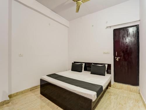 1 dormitorio con 1 cama en una habitación blanca en OYO Varusiya Guest House en Bhauli