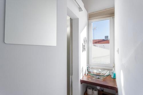リスボンにあるLisbon City Balconyの窓付きのバスルーム、木製テーブルが備わります。