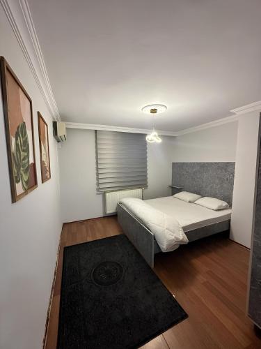 ein kleines Schlafzimmer mit einem Bett und einem Fenster in der Unterkunft Meydan Suite Apartments in Trabzon