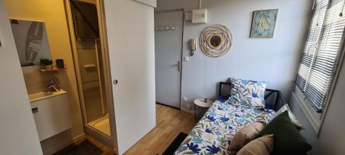 Cette petite chambre comprend un canapé et une fenêtre. dans l'établissement Adorable studette proche gare, à Chartres