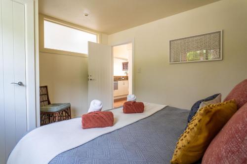 a bedroom with a bed with two stuffed animals on it at Koru Lodge in Raglan