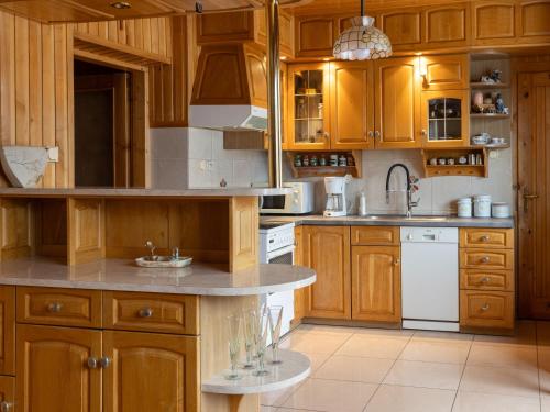 a kitchen with wooden cabinets and white appliances at Apartamenty w Gorcach in Nowy Targ