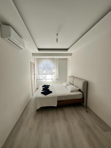 a white room with a bed and a window at Long Street Aparments in MEYDAN in Trabzon