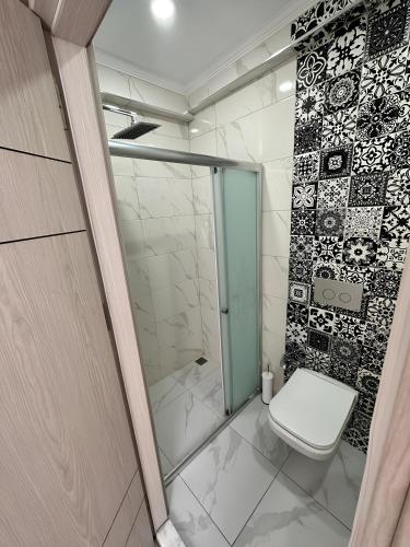 a bathroom with a glass shower and a toilet at Long Street Aparments in MEYDAN in Trabzon