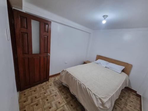 um quarto com uma cama e uma porta de madeira em Casa Turismo Terres em Cusco