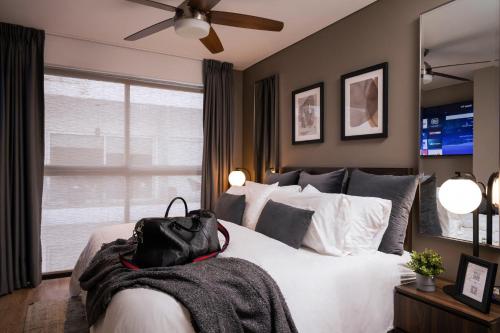 a bedroom with a bed with a black bag on it at Condesa Luxury Apartments in Mexico City