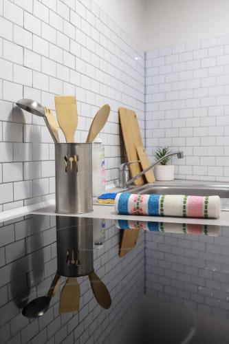 - un comptoir de cuisine avec un pot et des ustensiles sur une étagère dans l'établissement Appartement entier *au pied de la gare*, à Juvisy-sur-Orge