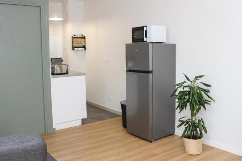 a refrigerator with a microwave on top of it in a room at Appartement entier *au pied de la gare* in Juvisy-sur-Orge