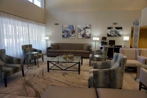 Best Western Tallahassee Downtown Inn and Suites في تالاهاسي: غرفة معيشة مع أريكة وكراسي وطاولة