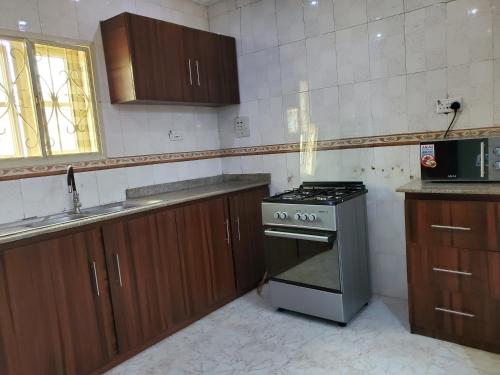 a kitchen with a stove and a sink at TSOLID HOMES ( SHORTLET & APARTMENT) in Ibadan