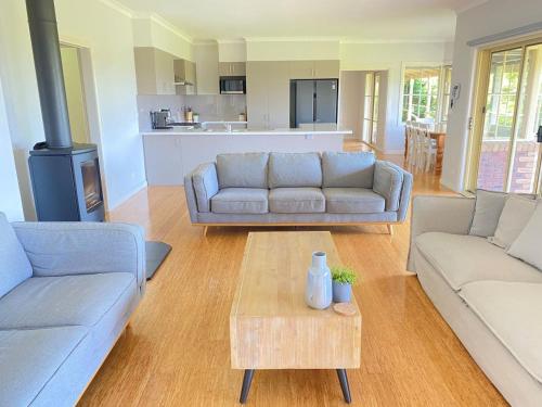 a living room with two couches and a coffee table at Farmhouse in the heart of wine country, 10 minutes to beach in Hastings