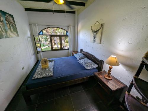 a bedroom with a blue bed and a table at spirit of jungle lodge in Sámara