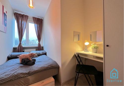 a bedroom with a bed and a desk and a window at Piggy Room in Gdańsk