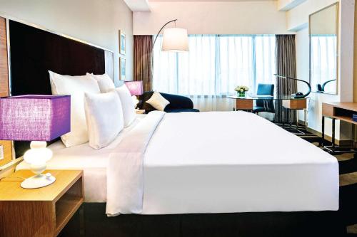 - un grand lit blanc dans une chambre d'hôtel dans l'établissement Wyndham Grand Bangsar Kuala Lumpur, à Kuala Lumpur