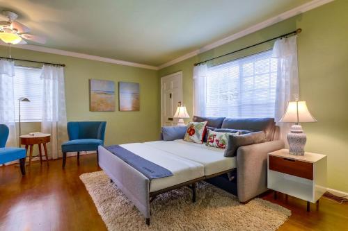 a bedroom with a bed and two blue chairs at OB Smiths Cottage By The Beach in San Diego