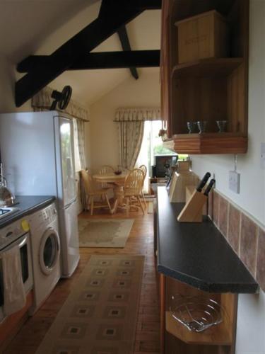 uma cozinha com máquina de lavar e secar roupa num quarto em Derbyshire Holiday Cottages em Holmesfield