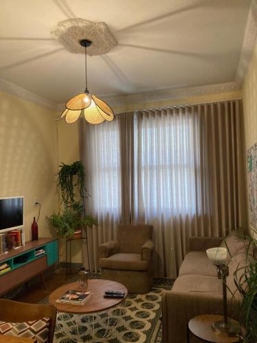 salon z kanapą i stołem w obiekcie Casinha do Prado, conforto vintage, ar condicionado w mieście Belo Horizonte