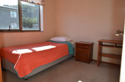 ein kleines Schlafzimmer mit einem Bett und einem Fenster in der Unterkunft Katri apart in Temuco