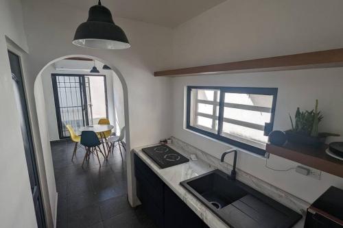 a kitchen with a sink and a window and a table at Loft ITSON: Comodidad + Asador in Ciudad Obregón